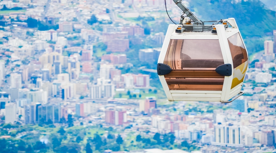 Closeup of cableway cabin hanging above the houses of the city of Quito in Ecuador with selective focus