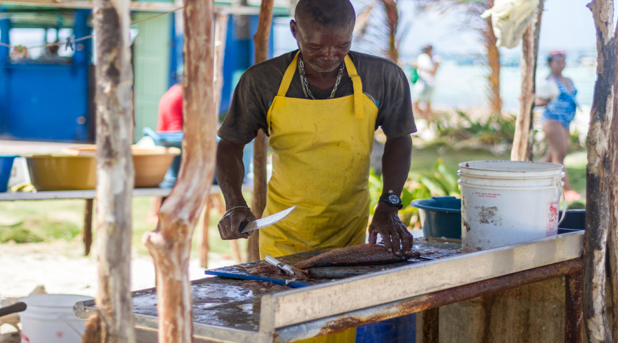 A-fisherman-rips-a-raw-fish-to-cook-in-an-outdoors-restaurant