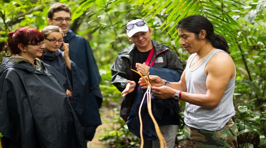 NATURALIST LOCAL GUIDE WITH GROUP OF TOURIST IN CUYABENO WILDLIFE RESERVE, ECUADOR 