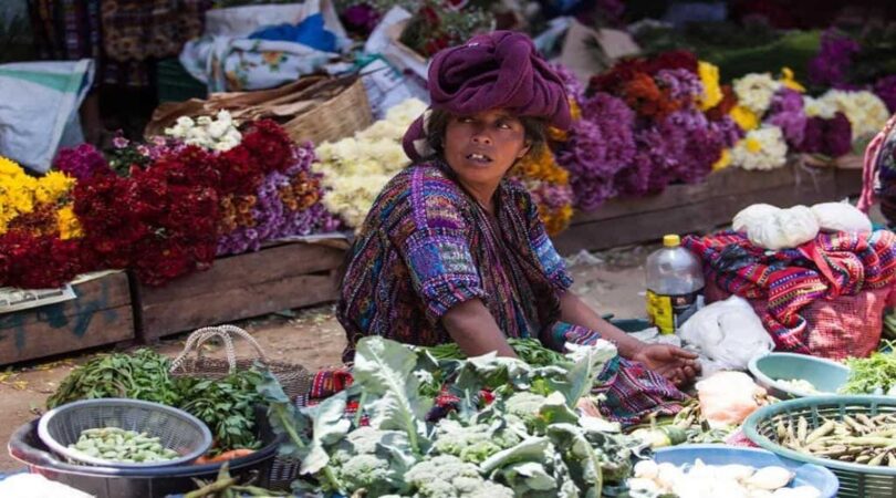 Middle-aged-indigenous-woman-sells-vegetables-and-flowers-at-traditional-weekly-market-in-Chichicastenango-Chichi-Guatemala.