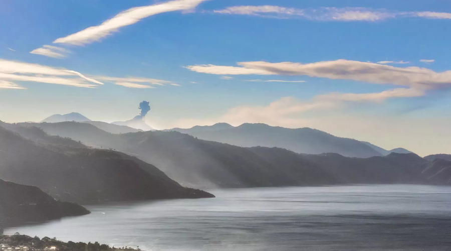 Picturesque-landscape-view-at-the-lake-Atitlan-and-the-smoking-active-volcano-at-the-background-as-seen-from-the-road-near-Panajach 