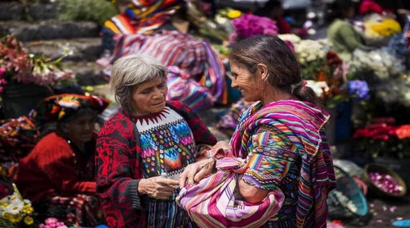 Two-local-women-wearing-traditional-clothing-in-a-street-market-in-the-town-of-Chichicastenango-in-Guatemala