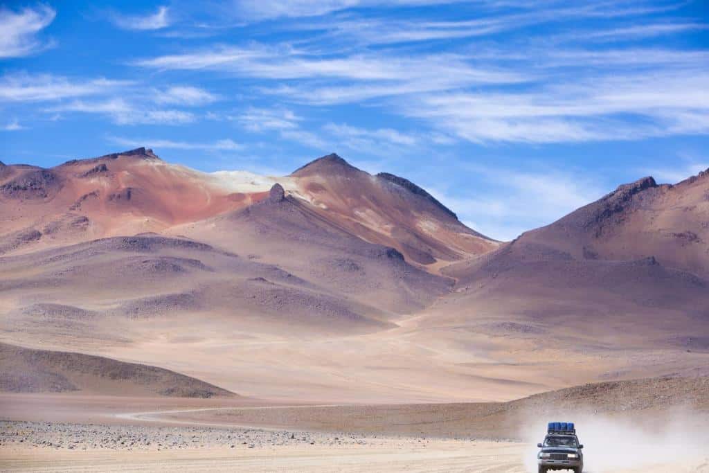 Off-road-vehicle-driving-in-the-Atacama-desert_Bolivia-with-majestic-colored-mountains-and-blue-sky-in-Eduardo-Avaroa-Andean-Fauna-National-Reserve