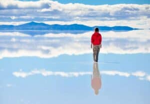 Girl-on-surface-of-salt-lake-Salar-de-Uyuni-in-Bolivia-with-sky-reflection