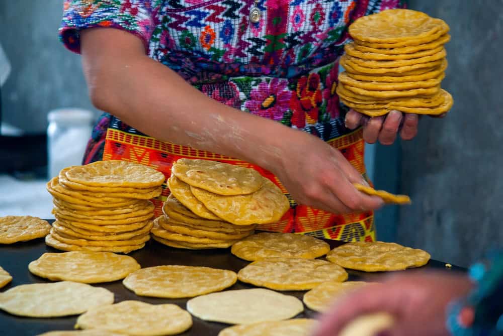 Handmade-corn-tortillas-on-a-metal-plate-called-22Comal22-in-Guatemala-City-indigenous-woman-and-Mayan-culture-in-Central-America