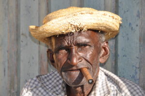 Picturesque-Cuban-old-man-is-on-one-of-the-streets-of-Trinidad-with-hat-and-cigar-scaled