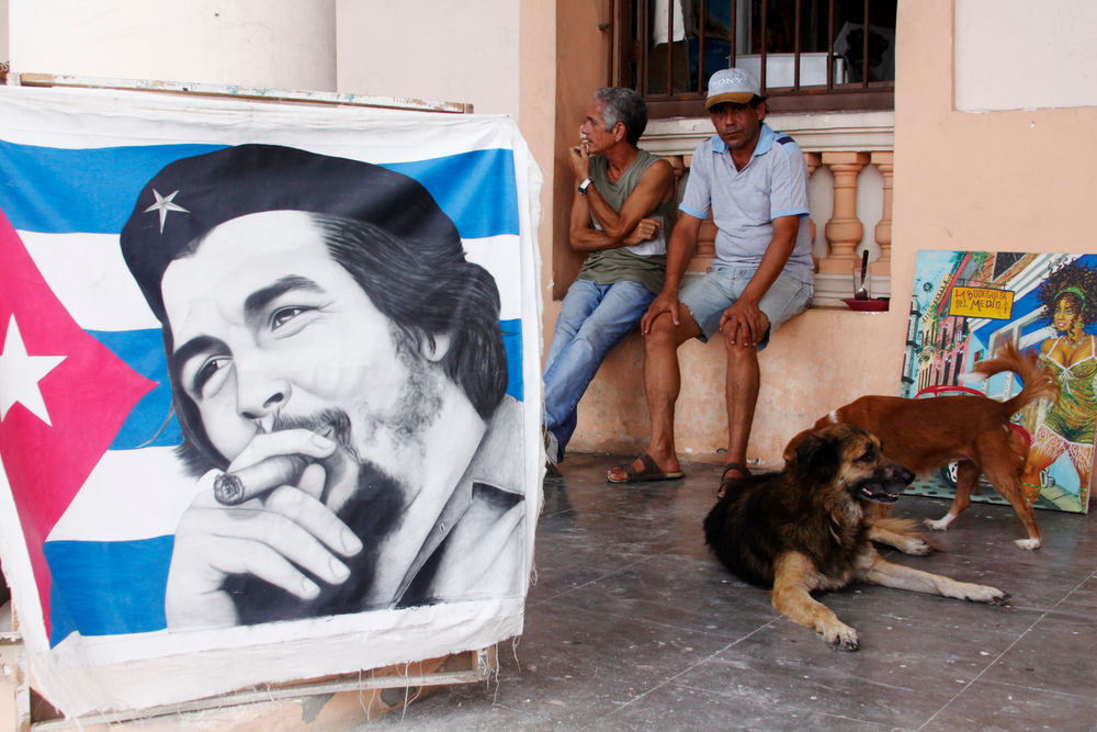 Street-scene-in-Havana-men-waiting-for-customers-to-sell-paintings-with-typical-Cuban