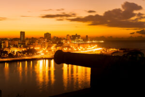 Sunset-in-Havana-with-a-view-of-the-city-skyline-and-an-out-of-focus-old-spanish-cannon-on-the-foreground