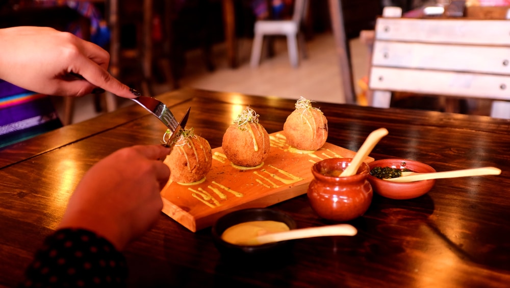 Balls made of green banana, "Bolones de verde" with cheese, peanuts, and/or pork chicharrones.