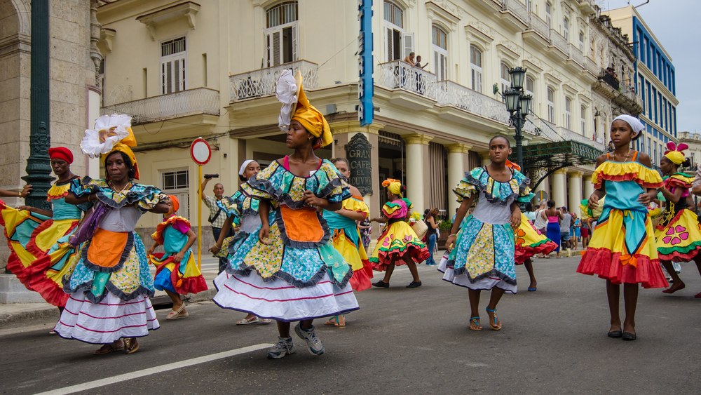 Dancers in colorful costumes celebrate Havana Day with a parade along Paseo de Marti in the historic La Habana Vieja 