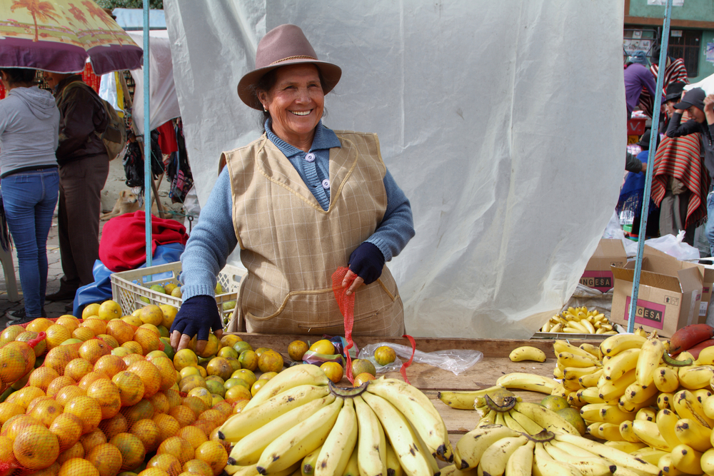 Ecuadorian-ethnic-woman-with-indigenous-clothes-selling-fruits-in-a-rural-Saturday-market