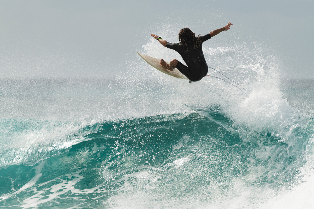 Havana, Cuba. Surfer jumping out of a wave on sea