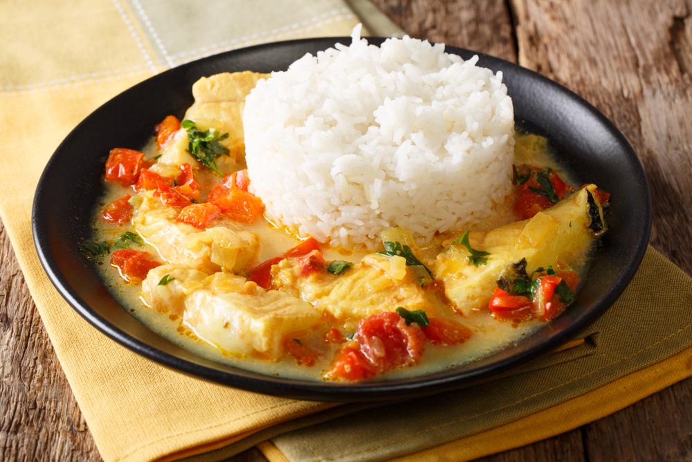 Pescado encocado or fish with coconut sauce close-up on a plate. Horizontal 