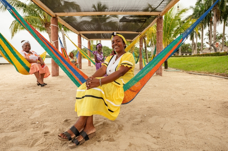 Portrait-of-a-group-of-Garifuna-women-sitting-in-hammocks-wearing-beautiful-dresses-typical-of-Livingston