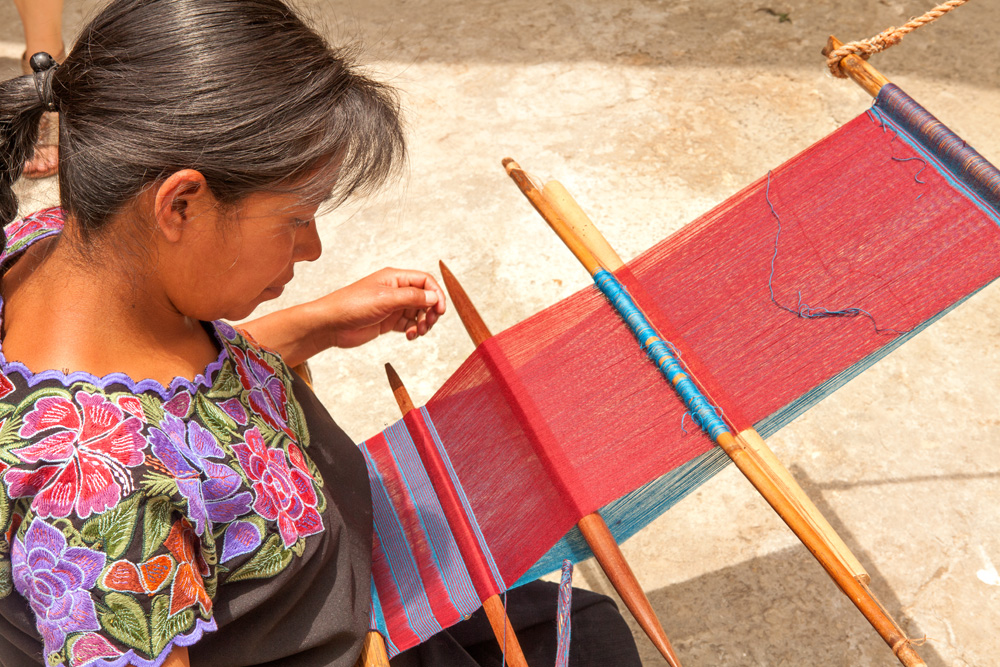 ndigenous-Tzotzil-woman-weaving-a-traditional-Huipil-at-the-loom.